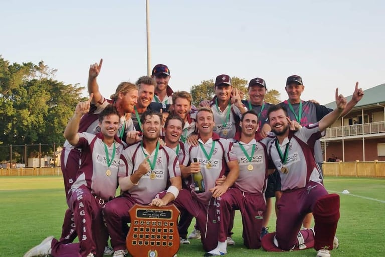 Championship winning baseball team celebrates on field with trophy in maroon and white uniforms